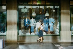 woman in blue dress walking on sidewalk during daytime