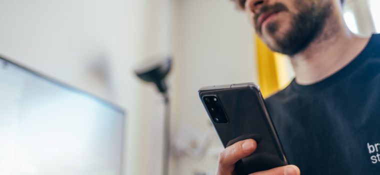 man in black crew neck shirt holding black iphone 5