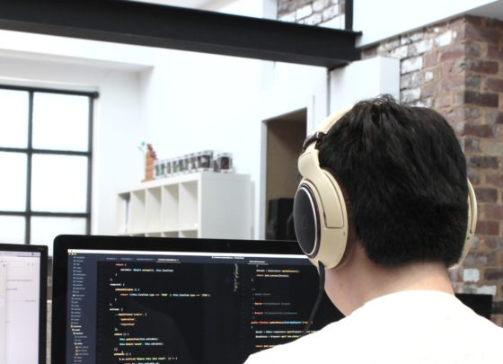 man wearing headphones while using computer