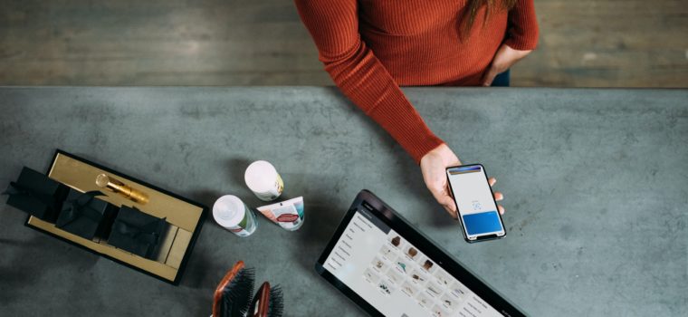 person holding smartphone beside tablet computer