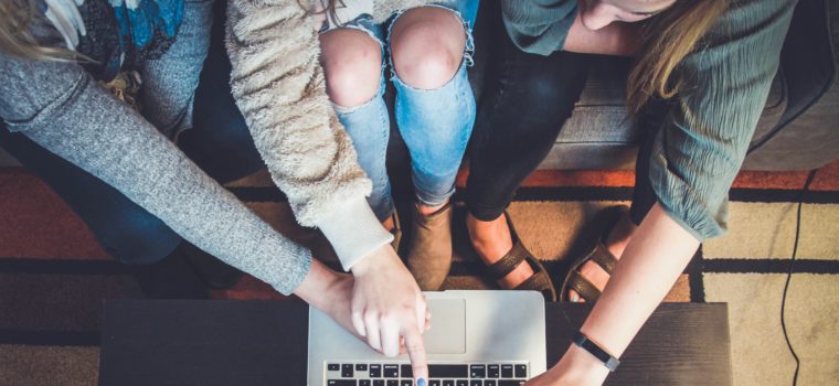 three person pointing the silver laptop computer