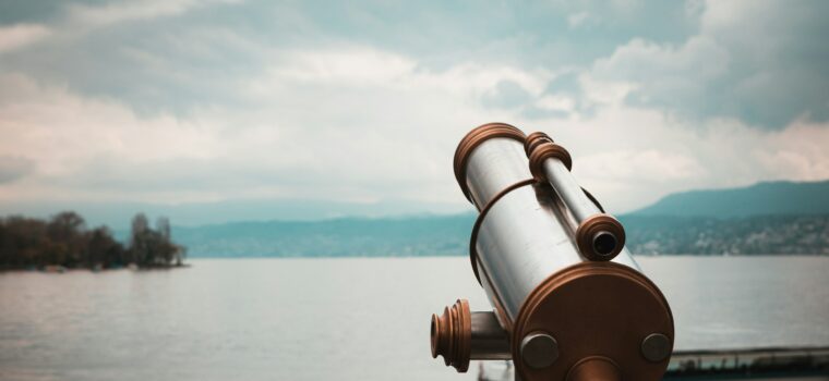 brown and silver telescope near body of water during daytime